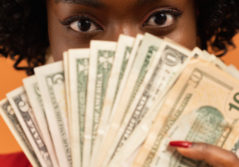 woman with afro showing money
